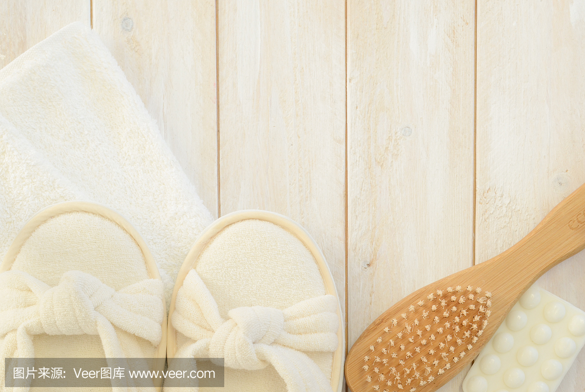 浴室拖鞋,毛巾,肥皂和刷子在木板上